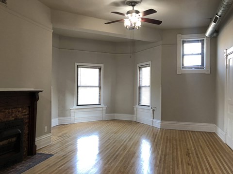A room with a fireplace and a ceiling fan.