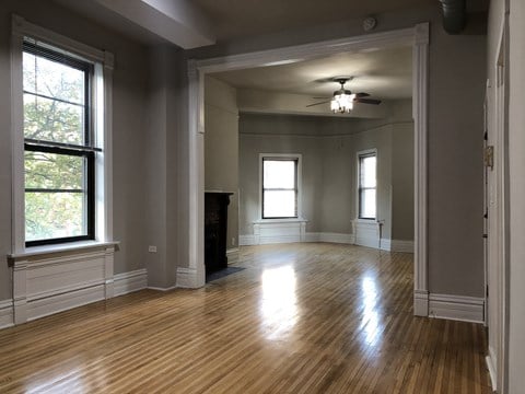 A room with wooden floors and a ceiling fan.