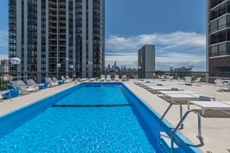 a swimming pool on the roof of a building with a city in the background