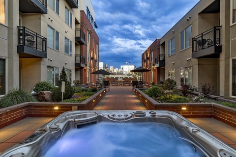 A pool in the middle of a courtyard surrounded by buildings.