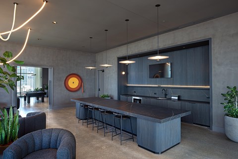 A modern kitchen with a large island and pendant lights.