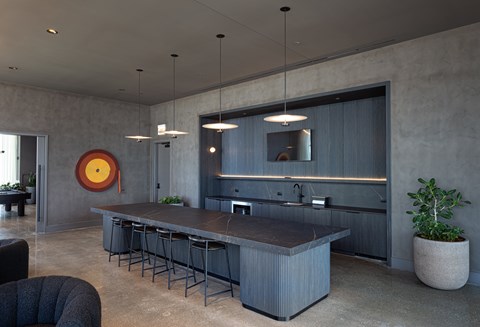 A modern kitchen with a large island and bar stools.