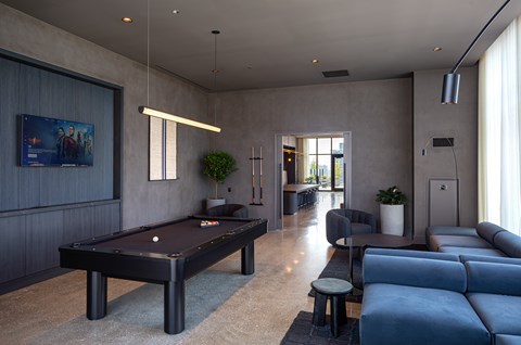 A room with a pool table and a couch.