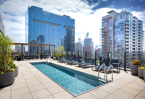 A pool on a balcony with a view of the city.