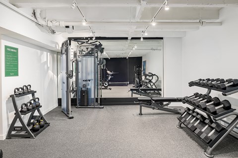 a gym with weights and a mirror in the back
