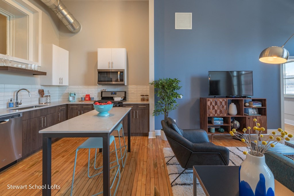 an open kitchen and living room with a table and chairs