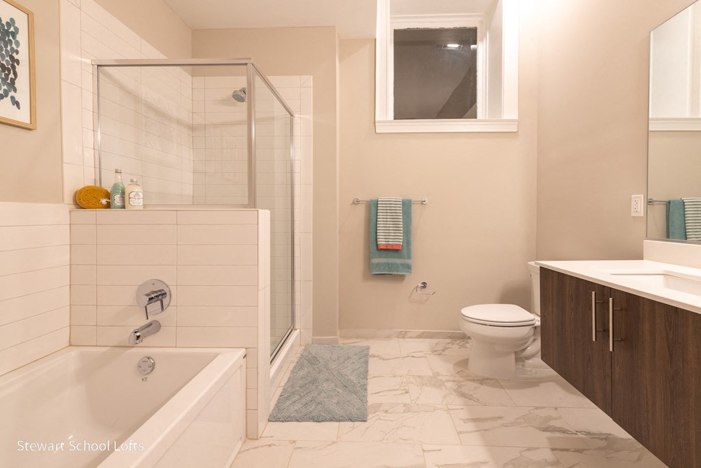 a bathroom with a shower and a toilet and a sink