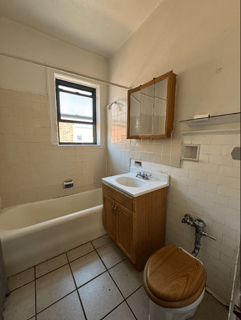 A small bathroom with a toilet, sink, and bathtub.