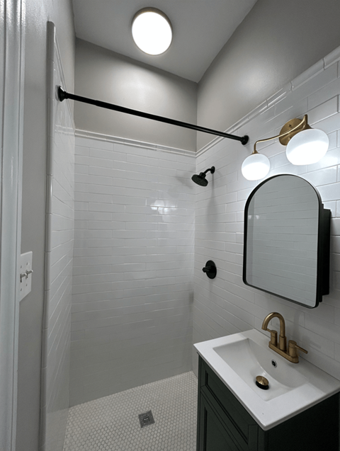 A bathroom with a white sink and a mirror.