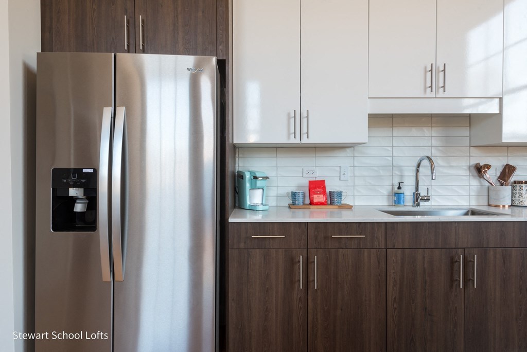 a modern kitchen with stainless steel appliances and white cabinets