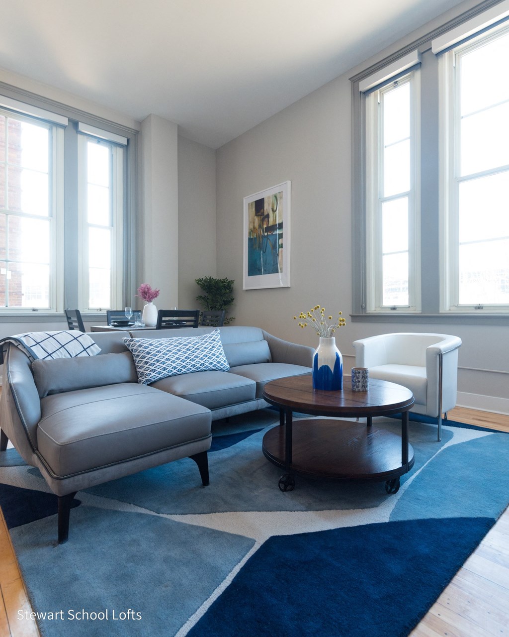 a living room with a blue rug and a couch and a table