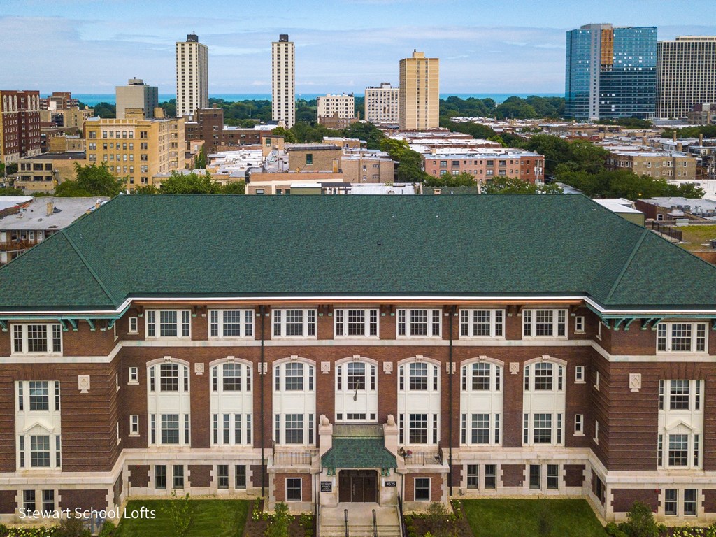 an aerial view of a large building with a city in the background