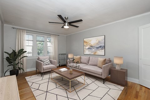 A living room with a grey couch, a coffee table, and a painting on the wall.