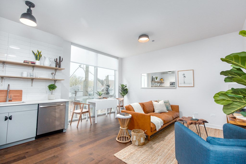 a living room with a couch and a kitchen and a large window