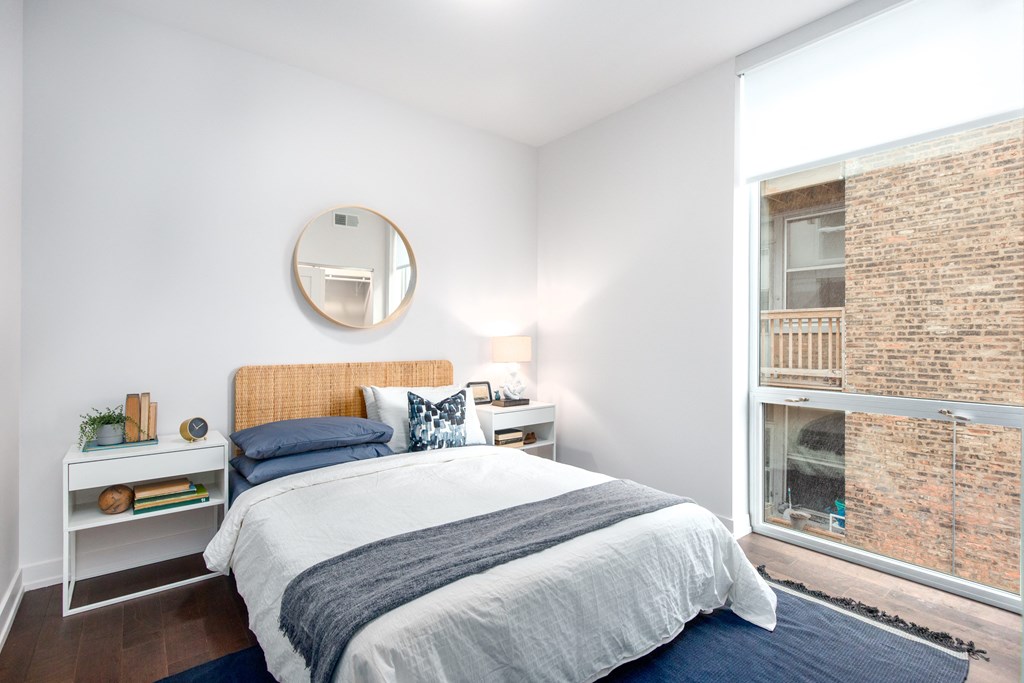 a bedroom with a bed and a large window