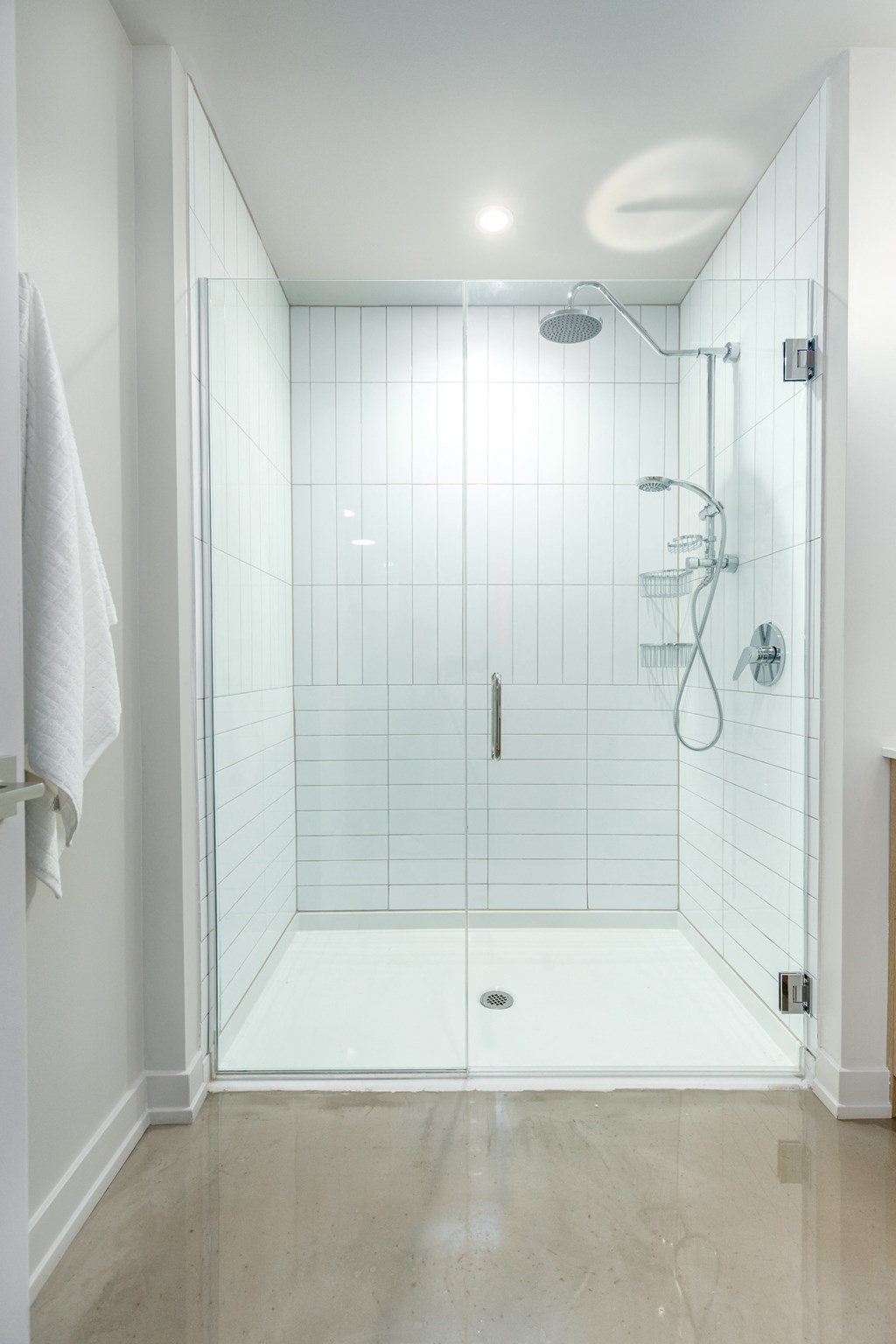 a large white tiled shower in a small bathroom