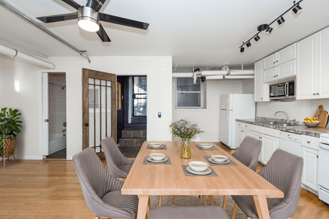 A dining room with a table set for four.