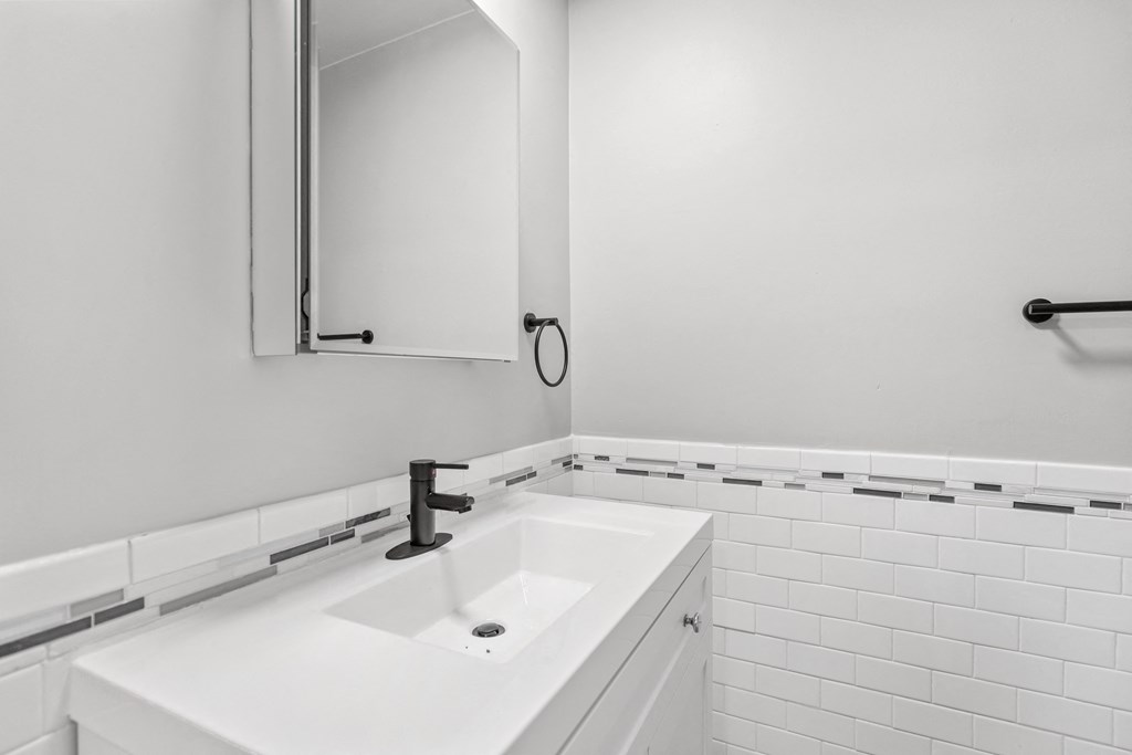 a white bathroom with a sink and a mirror