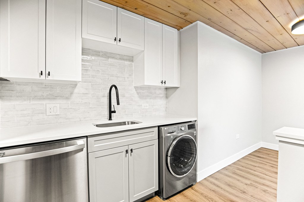 a white kitchen with white cabinets and a stainless steel dishwasher