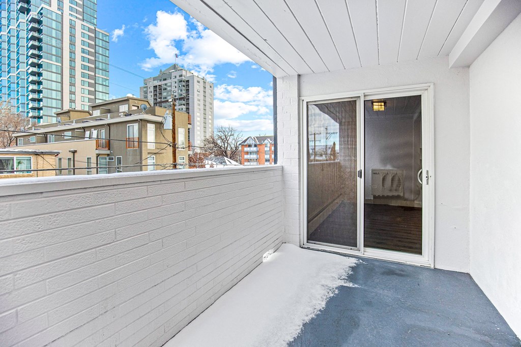 the balcony has views of the city and the door to the patio