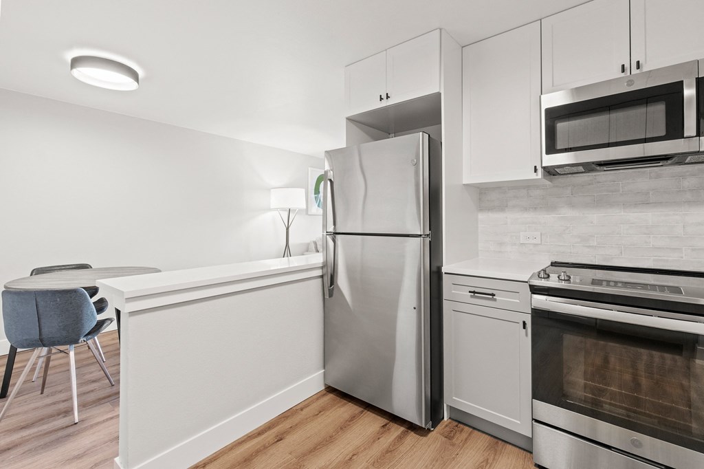 a kitchen with white cabinets and stainless steel appliances