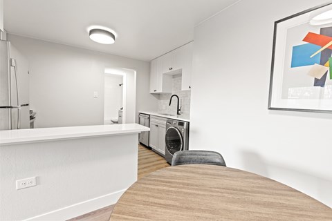 A modern kitchen with a washing machine in the corner.