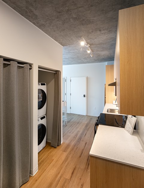 A modern kitchen with a washer and dryer built into the cabinetry.