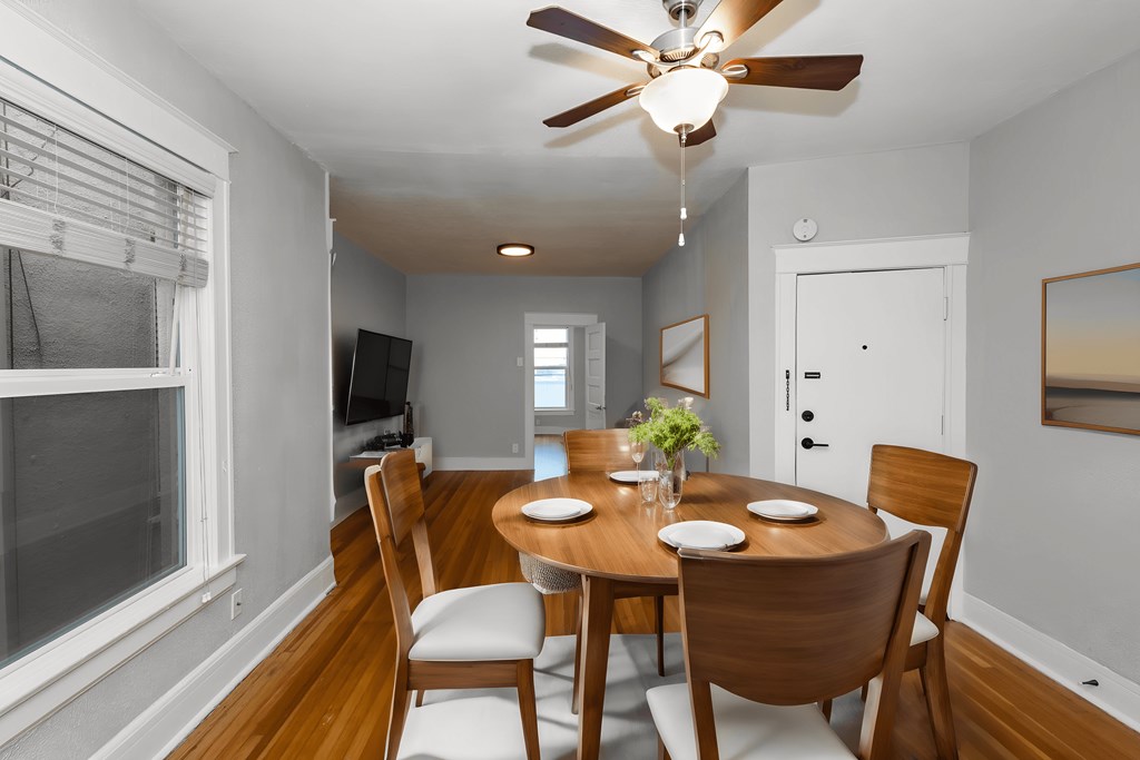 a dining room with a table and chairs and a ceiling fan