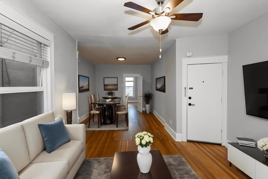 a living room with a couch and a table and a ceiling fan
