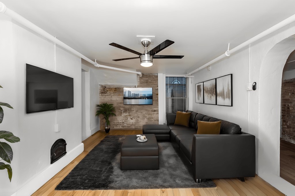 a living room with a leather couch and a tv