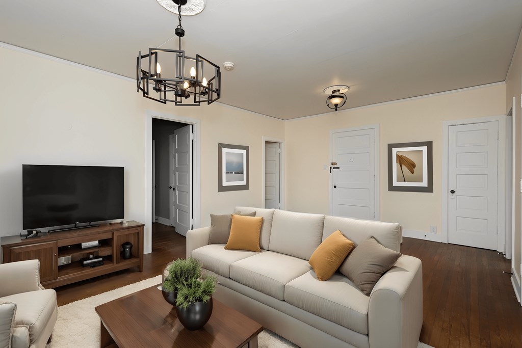 a living room with a white couch and a television