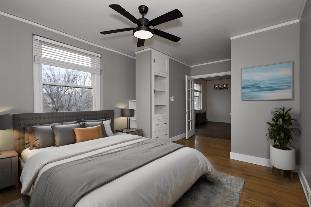 a bedroom with a large bed and a ceiling fan