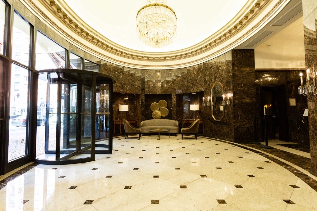 a hotel lobby with a couch and a chandelier