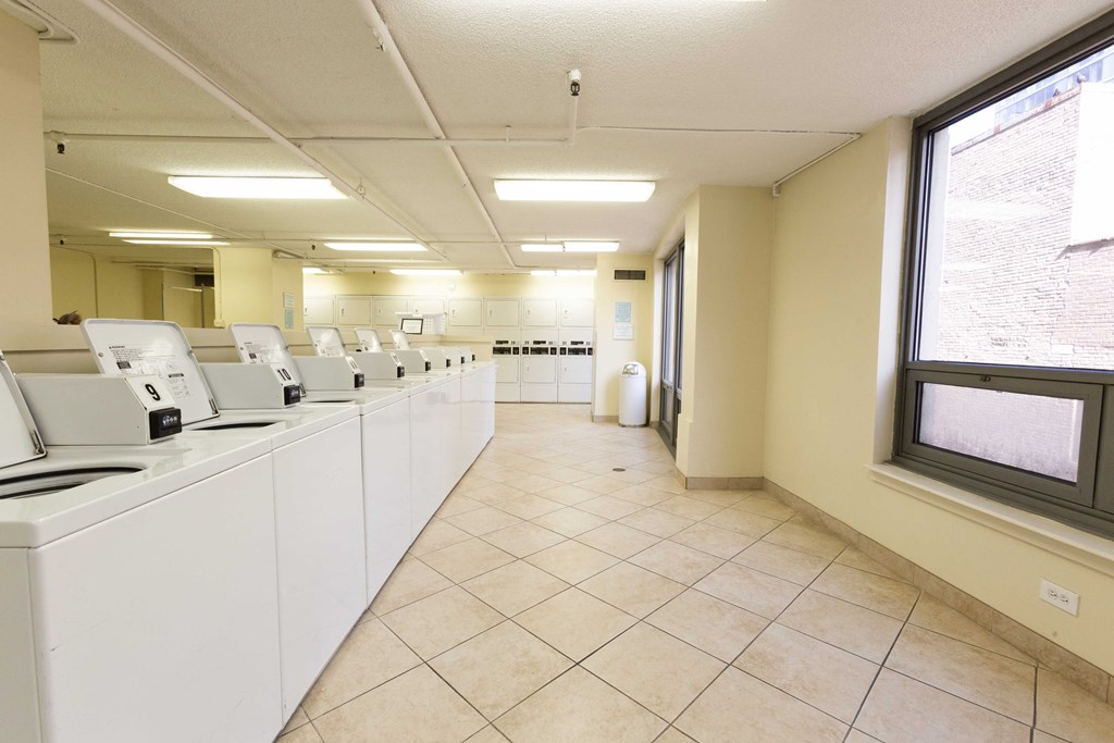 an empty laundry room with washers and dryers and windows