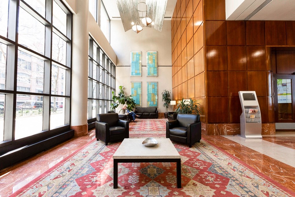 a lobby with a coffee table and chairs and large windows