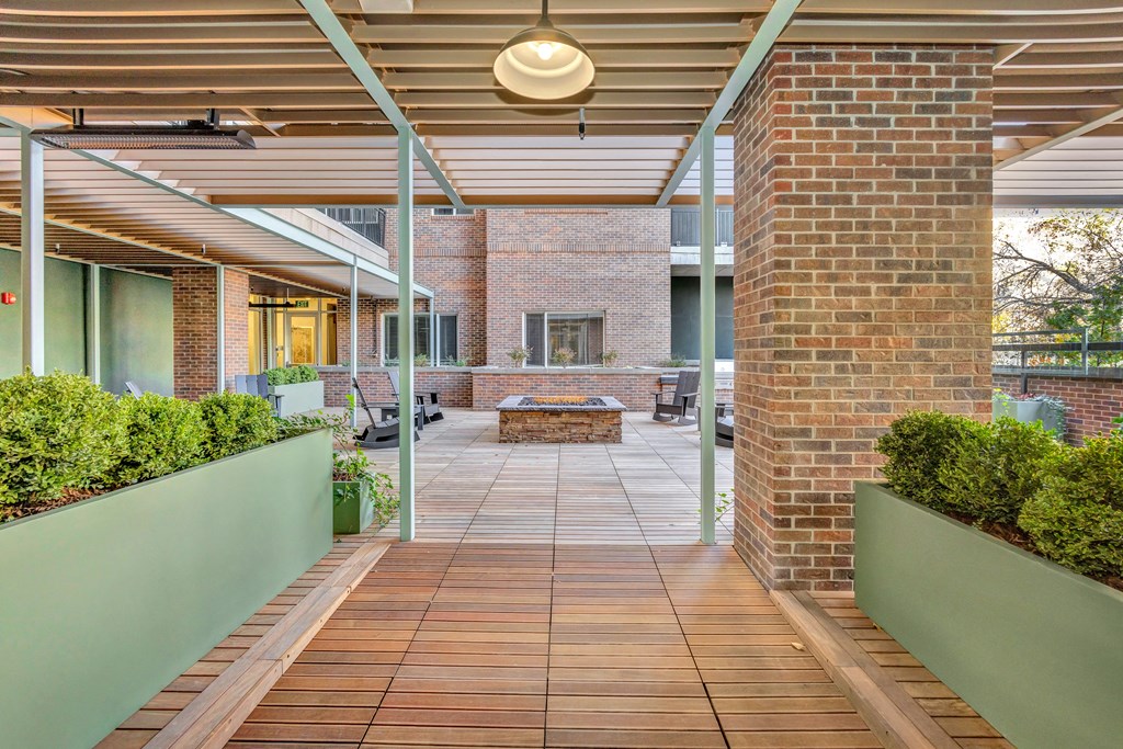 a covered porch with a brick wall and a fire pit