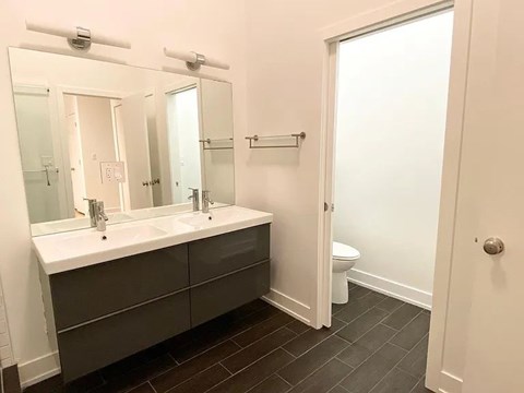 A bathroom with a white sink and a toilet.