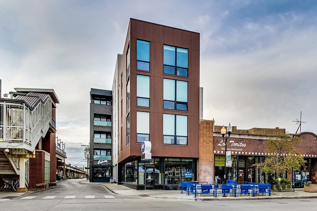 a building on a city street with a cloudy sky