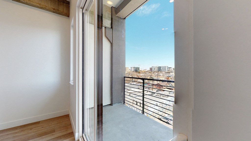a bedroom with a balcony and a view of the city