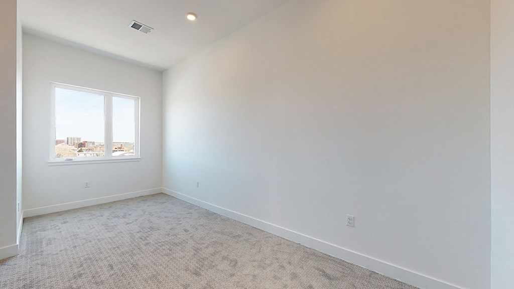an empty room with white walls and a window