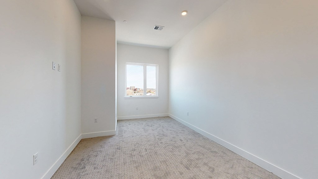 an empty room with white walls and a window
