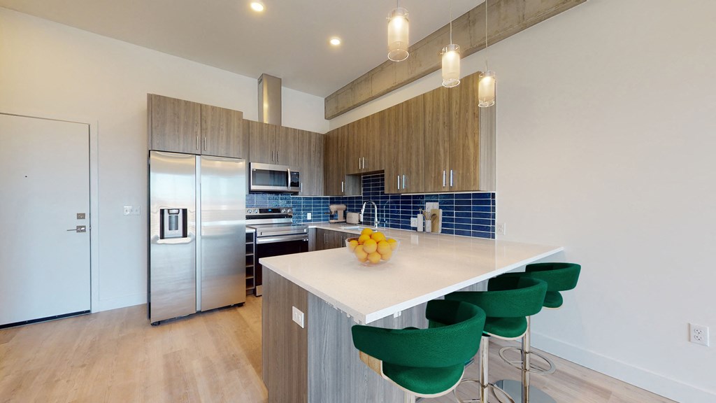 a kitchen with a large island with green stools
