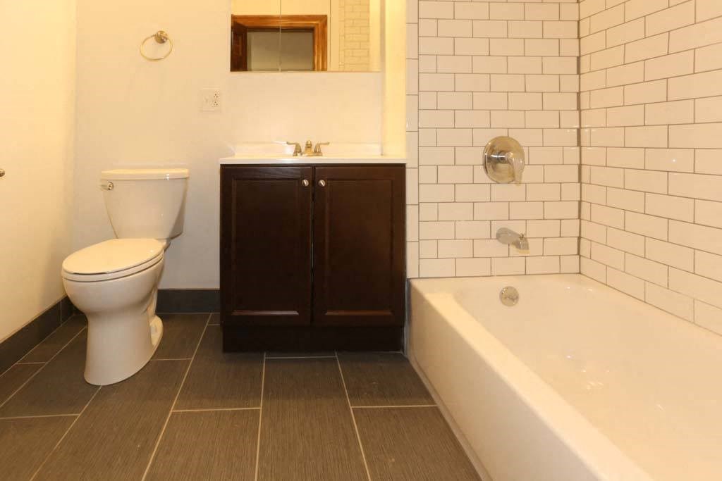 a bathroom with a toilet and a tub and a sink