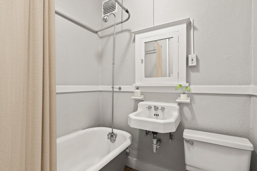 a bathroom with a sink toilet and bath tub and a mirror