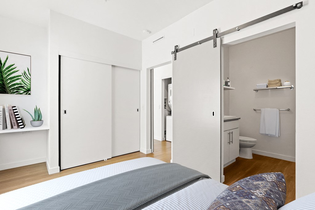 a bedroom with a bed and a bathroom with sliding doors