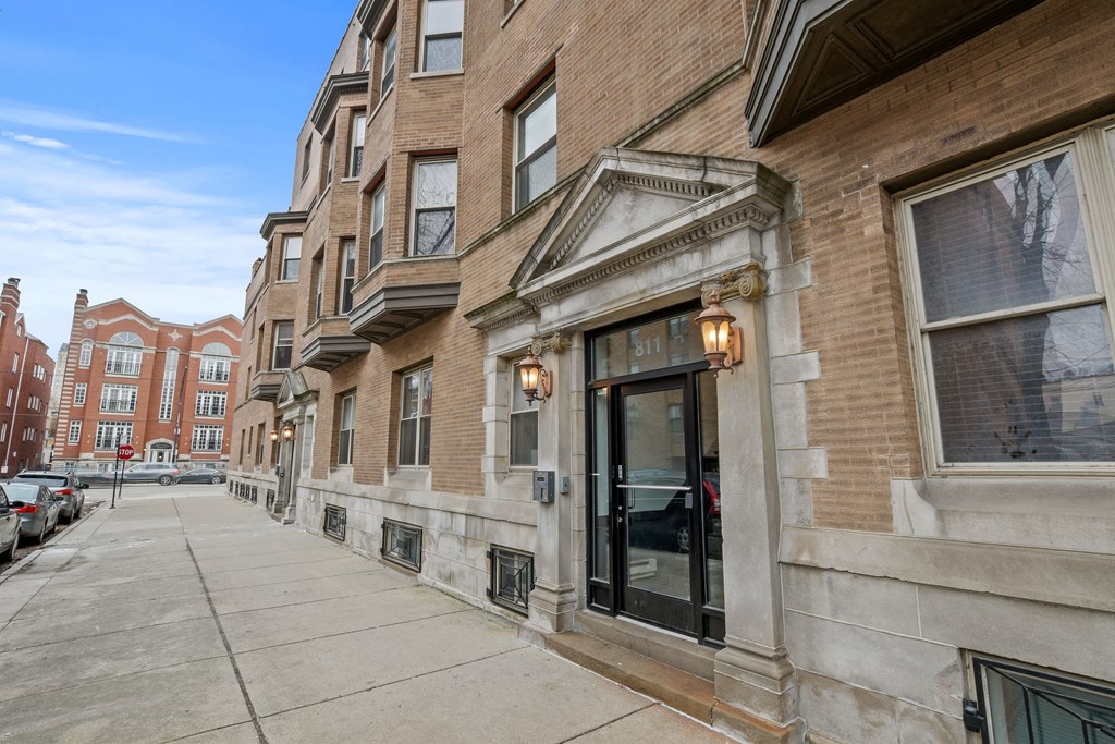 a brick building with a glass door on a sidewalk