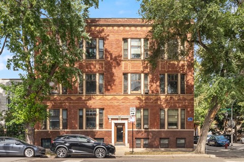 a red brick building with cars parked in front of it