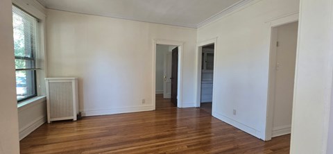 A room with white walls and wooden floors.