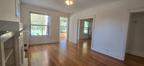 A large empty room with wooden floors and white walls.