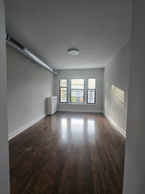 A room with wooden floors and a window.